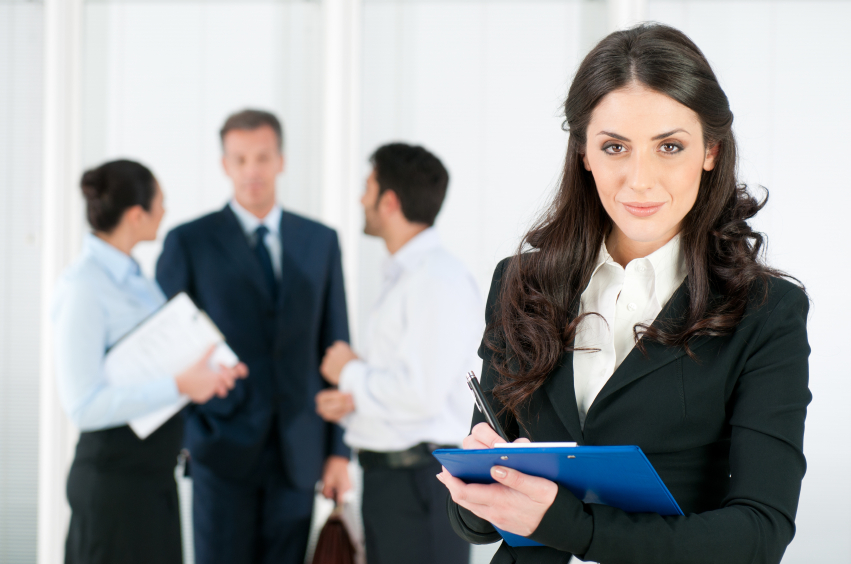 Satisfied smiling business woman compiling a form for a job recruitment or interview at office